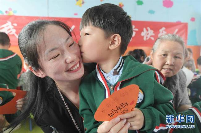 5月10日，在湖北省襄陽市一家幼兒園舉辦的母親節(jié)主題活動(dòng)中，一名小朋友將自己制作的賀卡獻(xiàn)給媽媽。 新華社發(fā)（安富斌 攝）